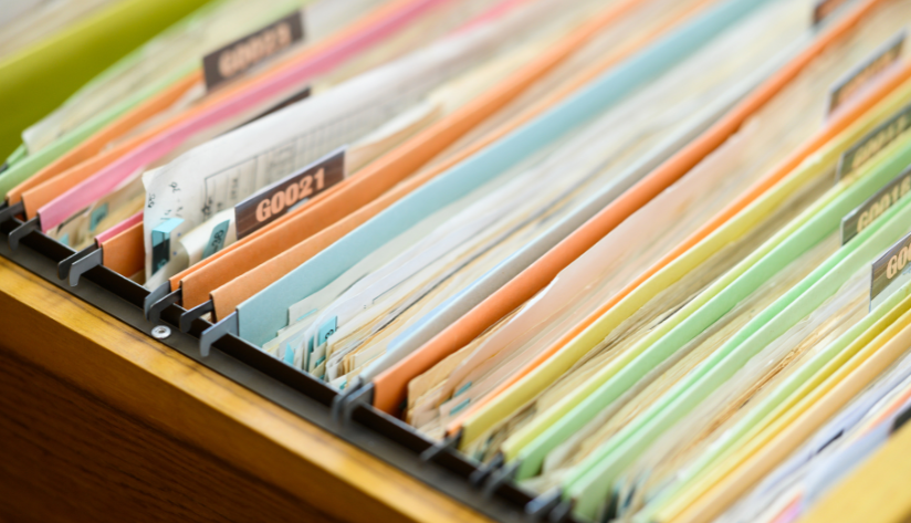 Asset tags and labels Color-coded files neatly arranged in an office filing cabinet, demonstrating the application of asset tags and labels in document and file management.