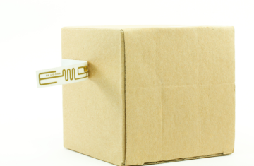 Close-up view of a small packaging box affixed with exquisite radio frequency identification labels, demonstrating the selection of RFID tags in procurement and product packaging applications.