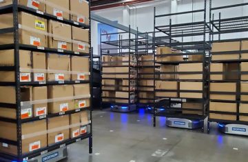 An automated warehouse with AGV robots and shelving illustrating RFID labels in sports retail supply chains