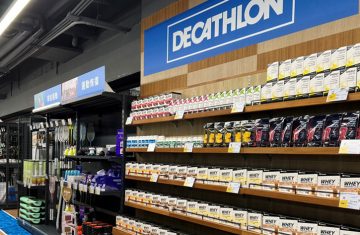 A well-stocked retail store interior featuring shelves of sports nutrition products under a Decathlon sign, highlighting RFID inventory management