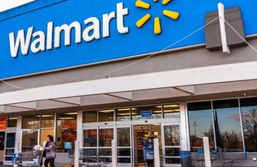 The exterior storefront entrance and blue signage of a Walmart retail supermarket