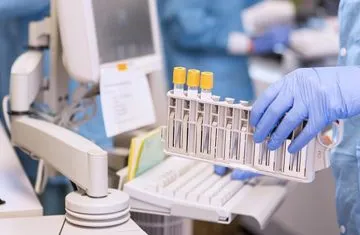 RFID Sample Tracking Medical technician handling a rack of blood sample test tubes in a hospital laboratory with precision RFID tracking