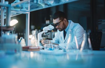 Scientist Working with a Microscope in a Modern Laboratory Setting