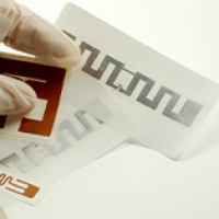 Person Wearing Gloves Handling RFID Labels and Inlays