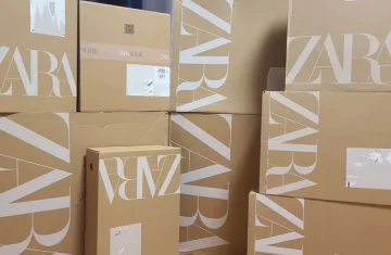 Stacks of brown cardboard boxes printed with the "ZARA" brand logo, illustrating Zara's reverse logistics code and the role of RFID in the fast-fashion return loop for the blog "Zara's Reverse Logistics Code: The Role of RFID in the Fast-Fashion Return Loop & Return Merchandise Authorization"