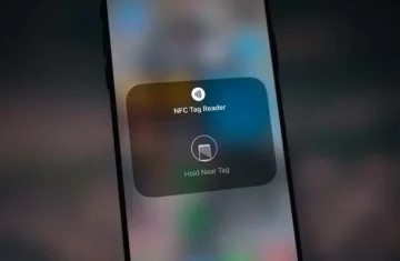 Close up of an iPhone displaying the NFC Tag Reader screen with the prompt Hold Near Tag.