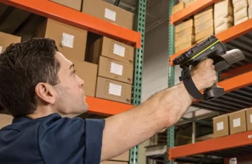 Warehouse Worker Using RFID Scanner A warehouse worker scanning items with a handheld RFID scanner.