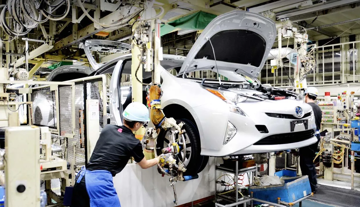 Robotic Arm Assisting Car Assembly Worker attaching the wheel of a car using an automated robotic arm