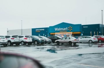 Walmart Store Front Walmart store exterior with a parking lot filled with cars on a rainy day.