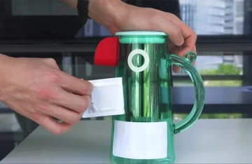 A person is attaching an RFID tag to a transparent container, demonstrating the use of RFID technology.