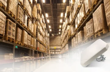 Warehouse with high shelving units and a circular polarized RFID antenna installed in the foreground.