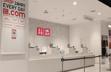 A retail store display showcasing the UNIQLO brand with information on 24-hour shopping and features like Click and Collect.