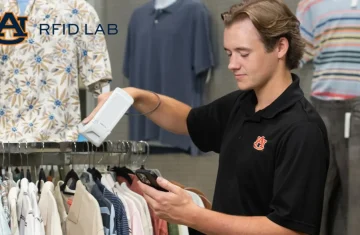 Retail Research and Testing at the Auburn RFID Lab A young male researcher at the Auburn RFID Lab uses a handheld RFID reader to scan clothing items on a retail rack.