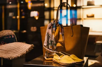 The Unbreakable Shield How We Empower Consumers to Defeat NFC Counterfeit Threats Yellow leather tote bag with a floral scarf and matching shoes displayed in a softly lit boutique window.