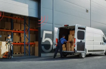 Worker with a hand truck (left) loads boxes into a van (right) at a warehouse dock, with RFID signal icons.
