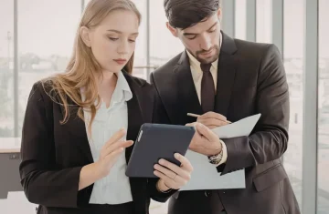 Not Sure Which RFID Label to Choose, Start With These 5 Questions Two business professionals review information on a tablet and document in a modern office.