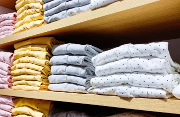 Folded clothing on retail shelves, showing an organized store display that benefits from retail clothing security and accurate inventory control.