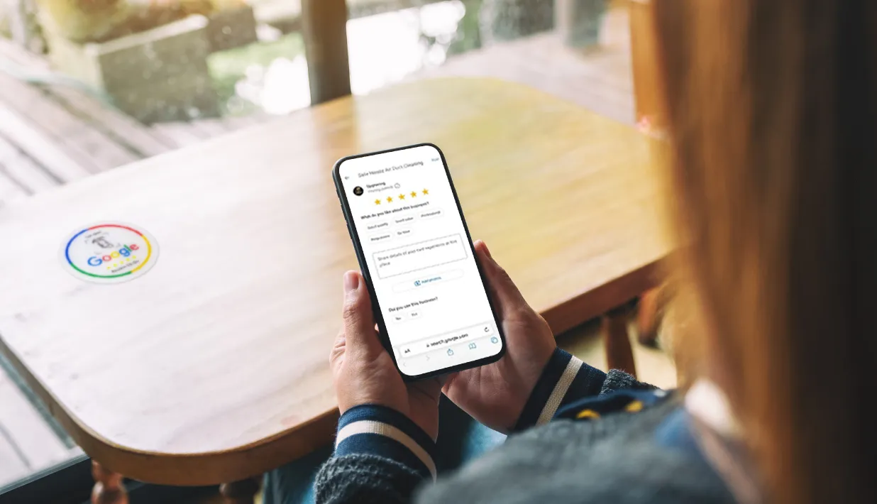 Customer using smartphone to leave online review with NFC review sticker.